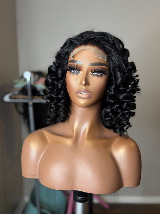 Front view of Naomi glueless Deep Wave wig styled in soft, voluminous wand curls with a natural black finish.