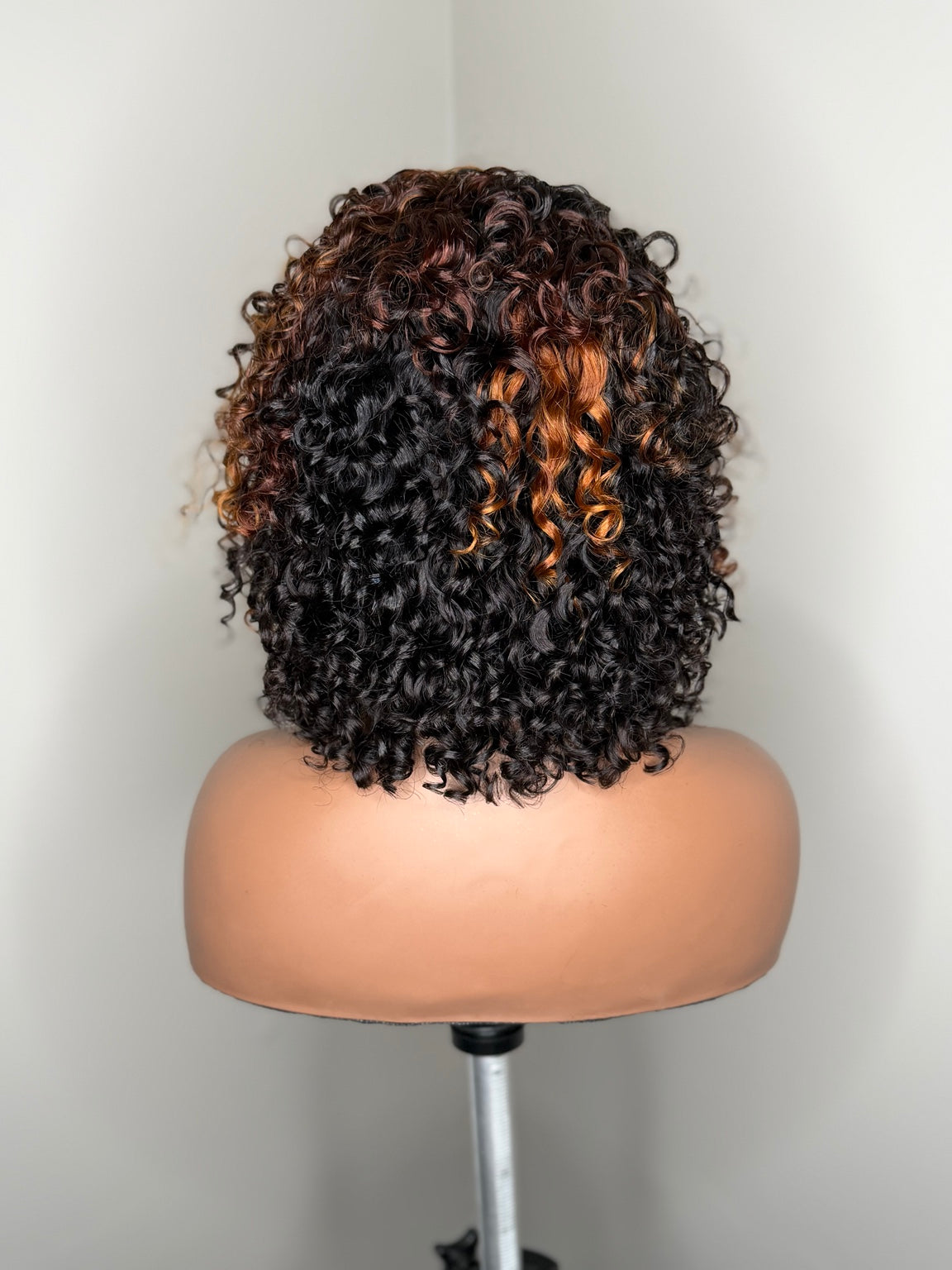 Back view of Camille dimensional curly wig showing full curl pattern with copper and auburn highlights