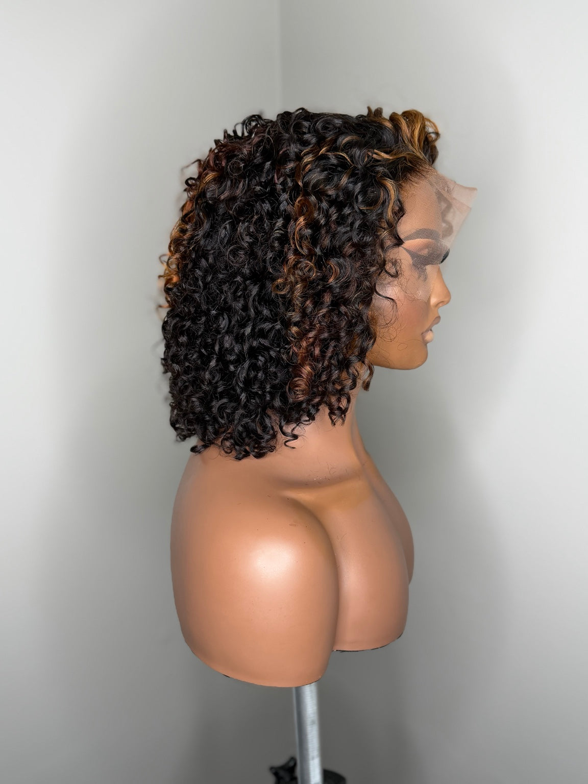 Profile view of Camille curly lace wig with deep brunette curls and warm caramel copper highlights