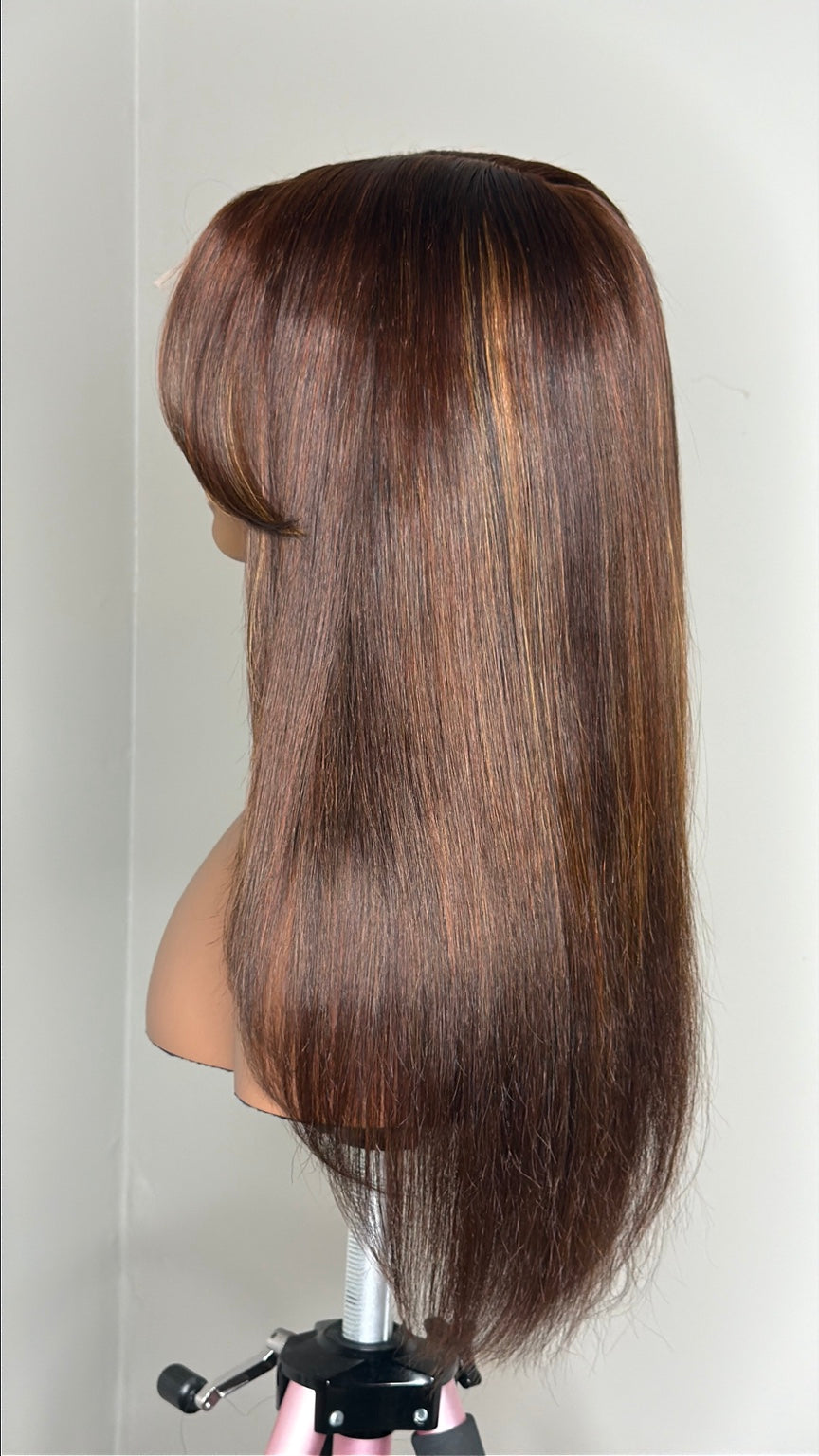 Dimensional brunette wig side and back detail showing subtle warm golden highlight placement