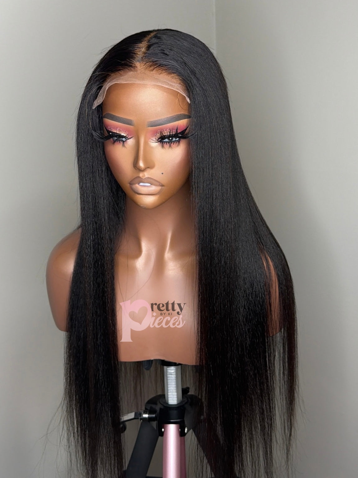 Finished example of Neesha Natural kinky straight wig, front view with Pretty Pieces by Ki logo